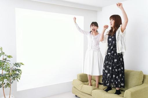 椅子の上で、1名はマイクで1人がアカペラで、椅子の上で歌っているシーン